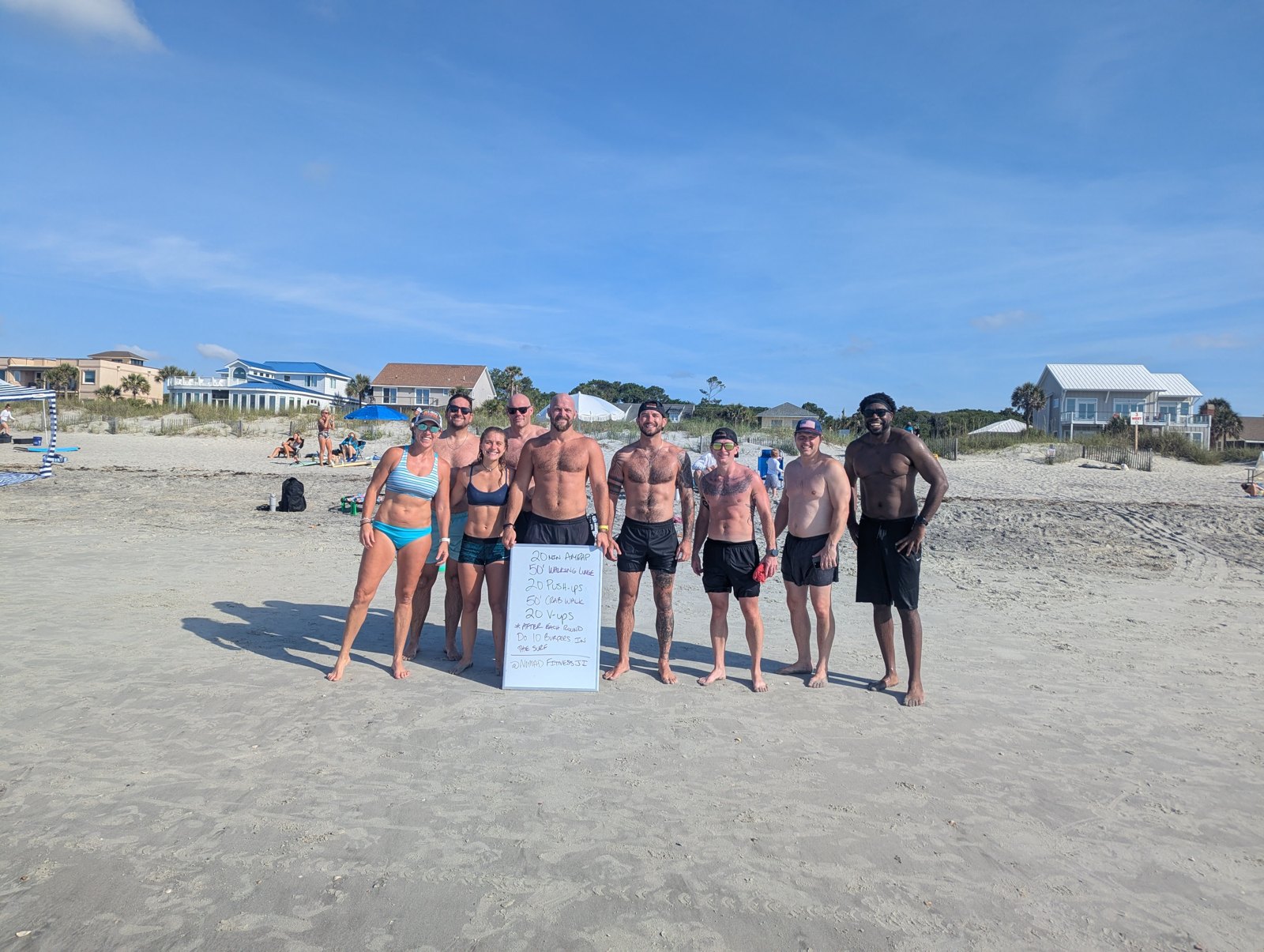 Nomad Fitness members gathered together on the beach after an outdoor workout