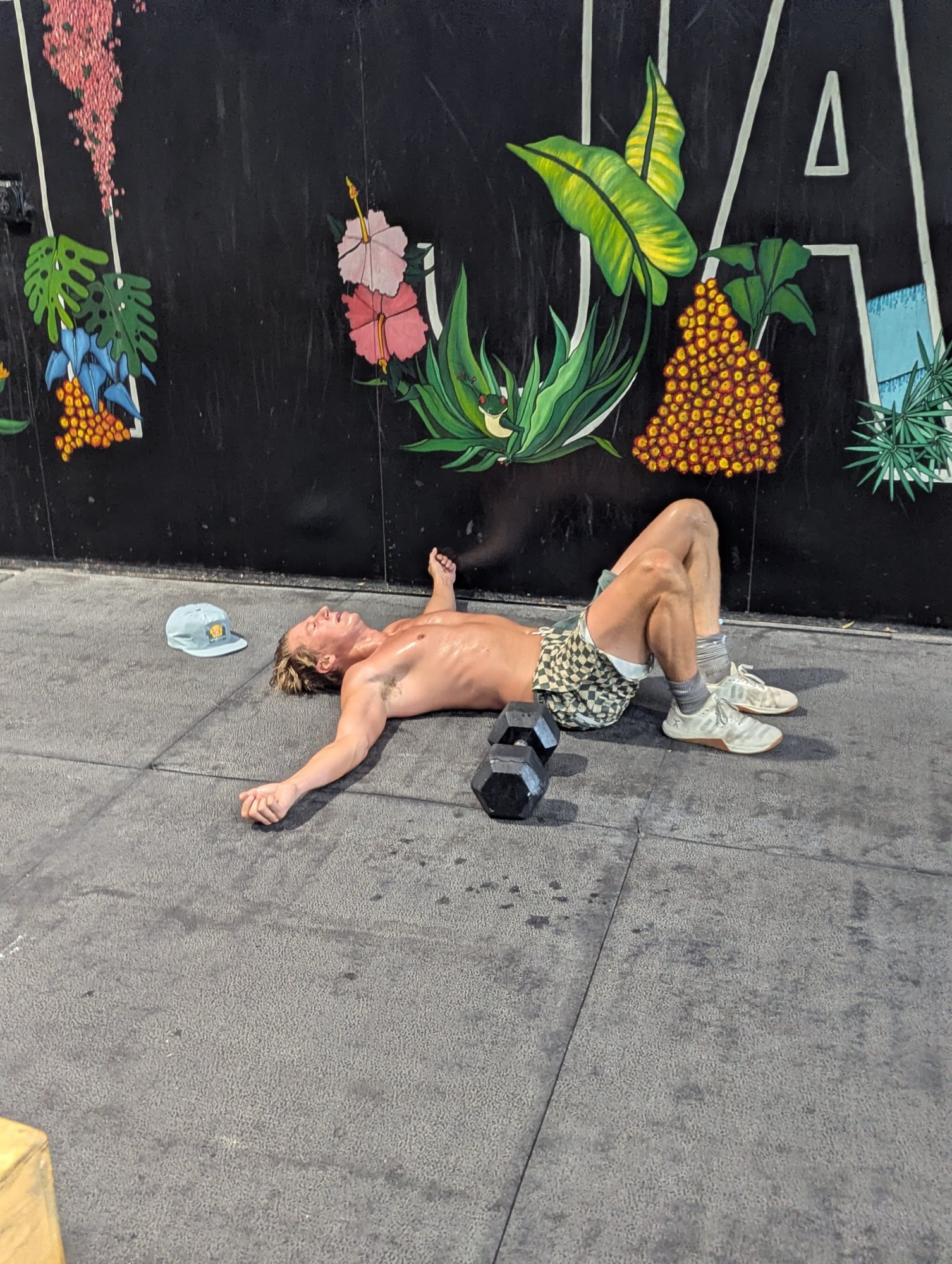 A Nomad Fitness member resting after training beside the Nomad mural